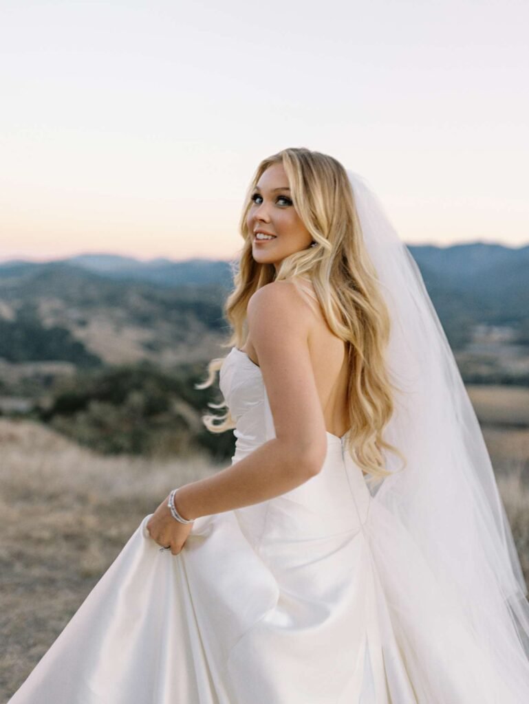 Bride wearing elegant natural wedding makeup with glowing skin, soft neutral eye makeup, rosy lips, and timeless bridal hairstyle.